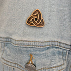 Bronze Trinity knot pin on a denim jacket