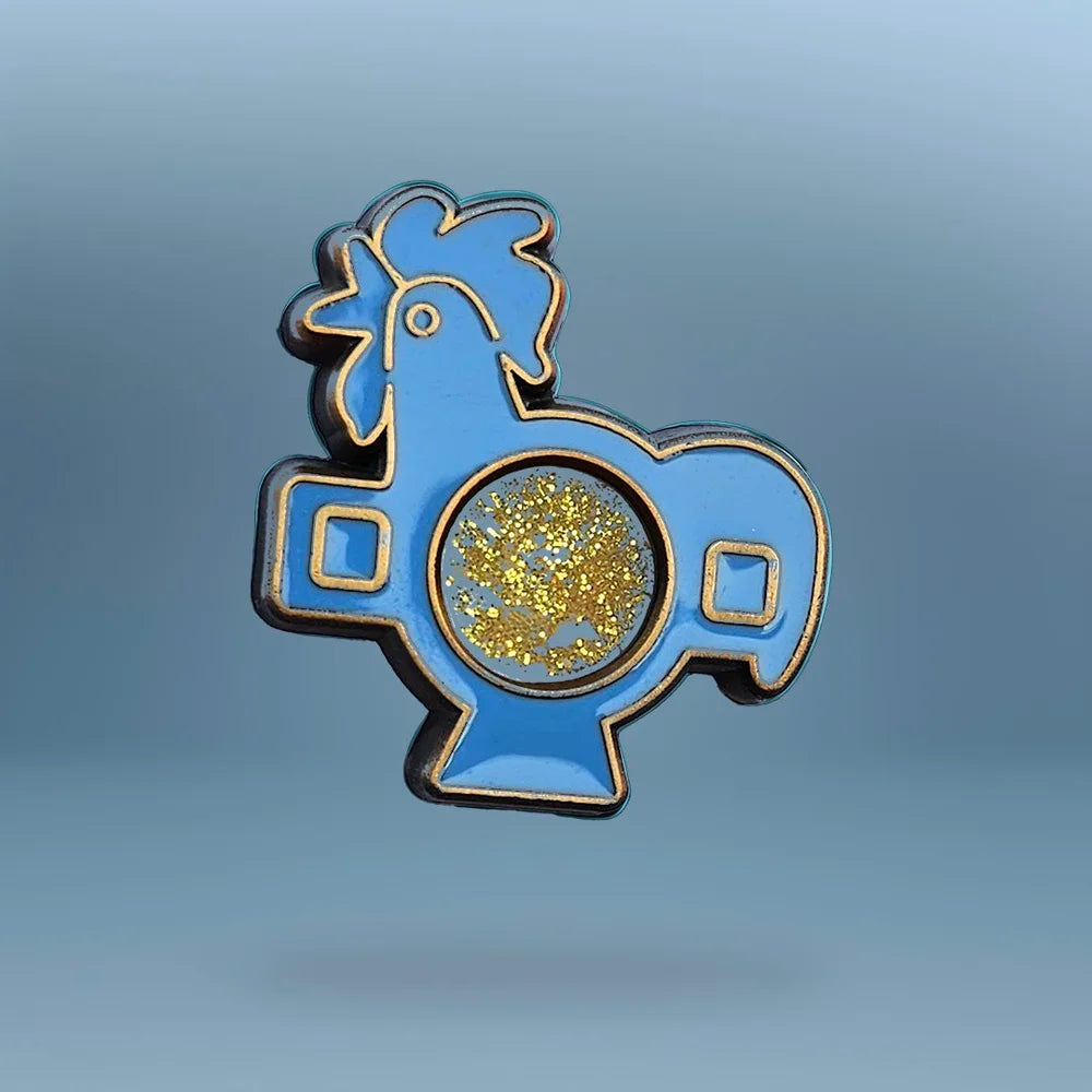 Blue rooster-shaped pin with gold liquid centre on a grey background