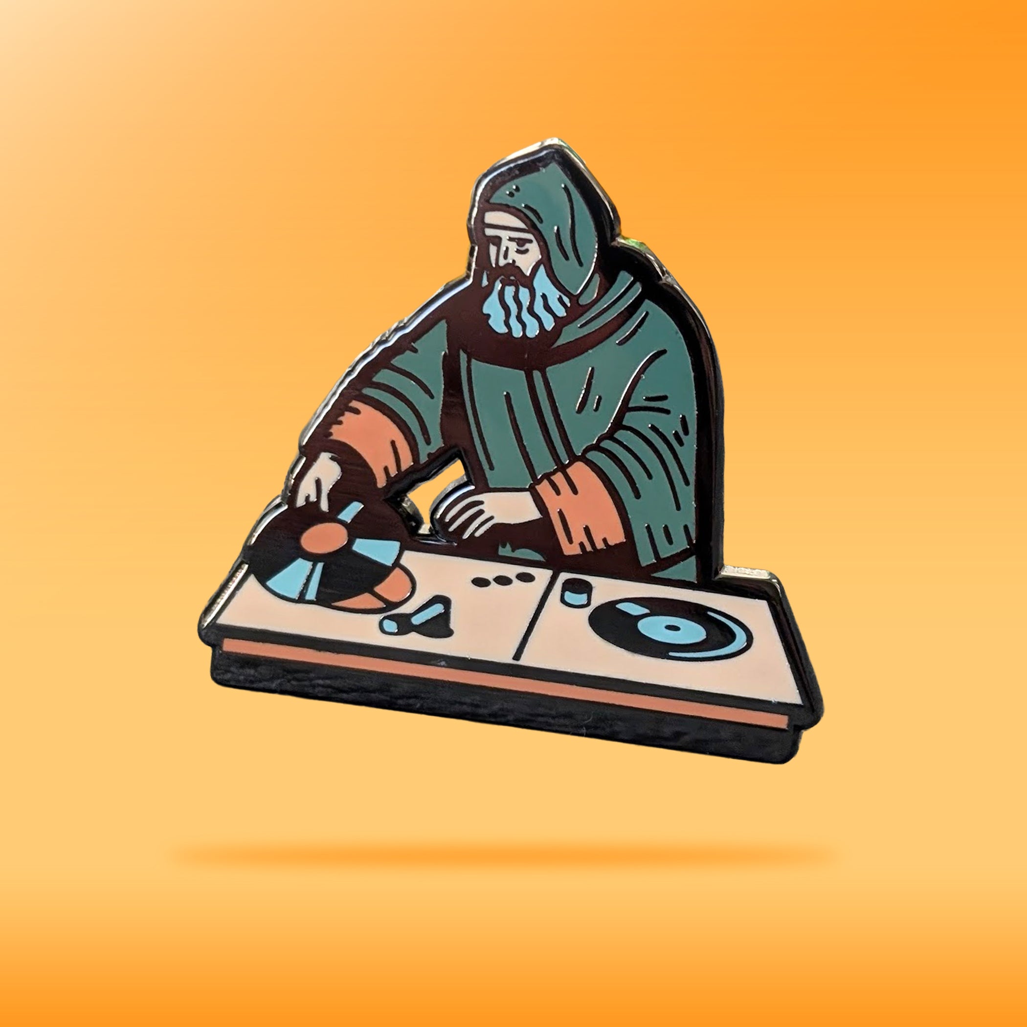 A pin showing an old monk playing the DJ Decks and it's called 'Maniac 1000'