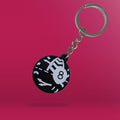 The Naas Ball depicted as a Magic 8 Ball as a Black and White PVC Keychain, agaisnt a pink packground