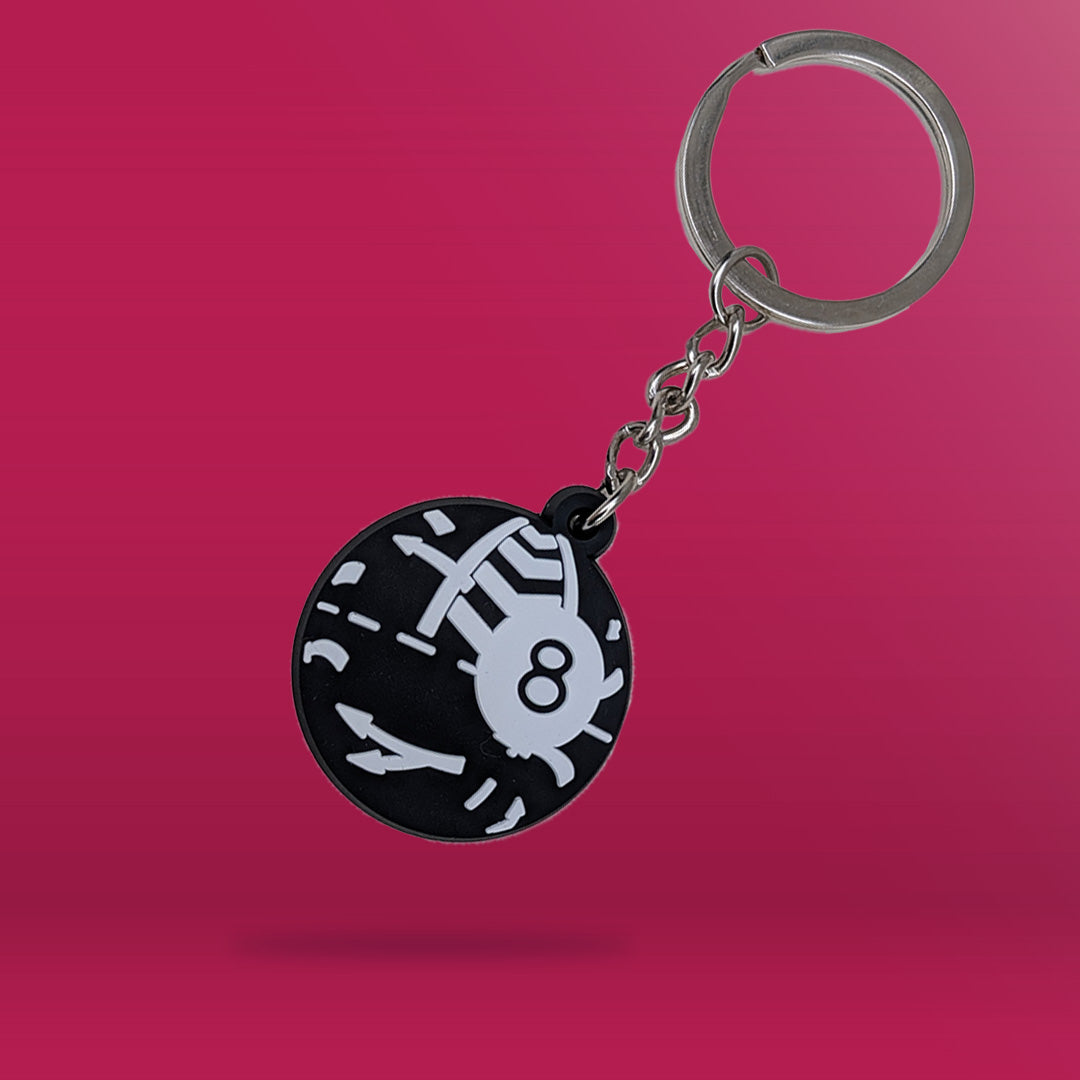 The Naas Ball depicted as a Magic 8 Ball as a Black and White PVC Keychain, agaisnt a pink packground