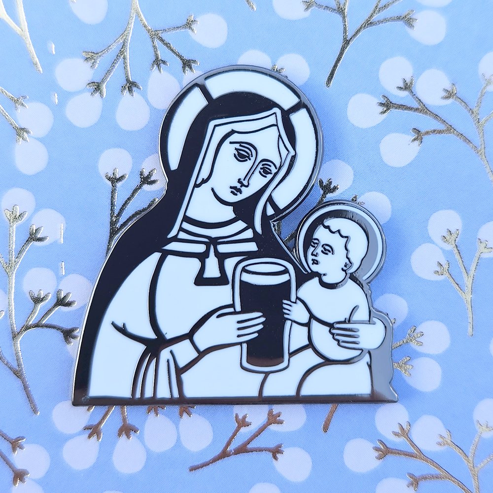 Enamel pin with a design of a woman holding a child and a glass of stout against a blue background with white snowflakes and branches.