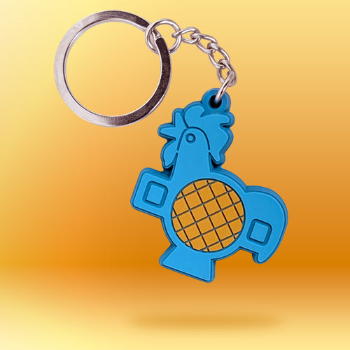 A blue rooster-shaped keychain with a silver metal key ring and chain, shown against a yellow-to-orange gradient background.