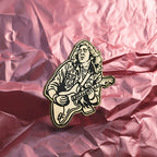 Enamel pin of guitarist Rory Gallagher on crumpled pink paper