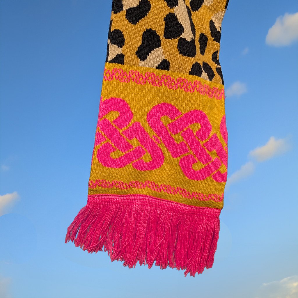 Scarf with leopard print and pink celtic knot against a blue sky