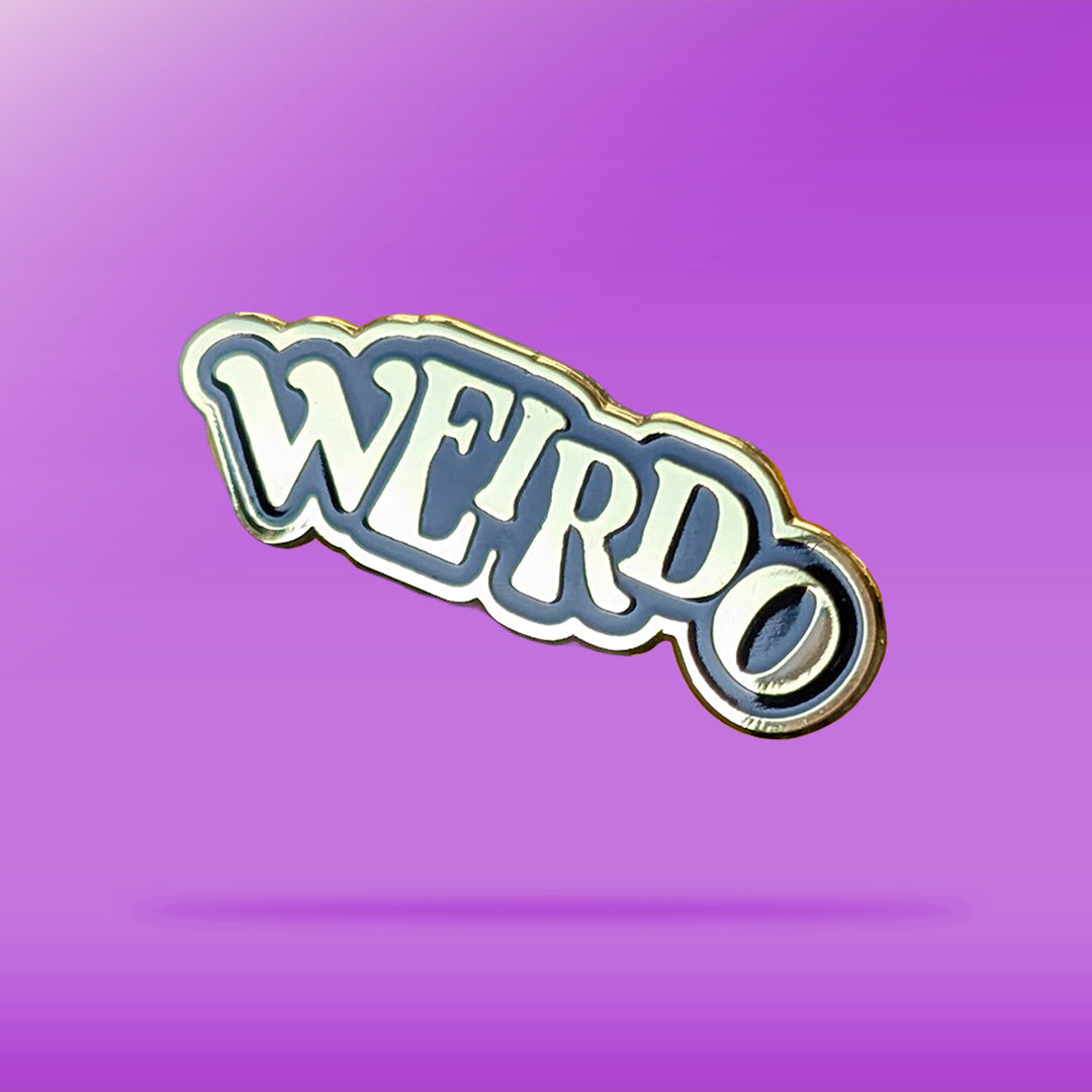 A black and Gold pin that reads 'weirdo' in offset text against a purple background